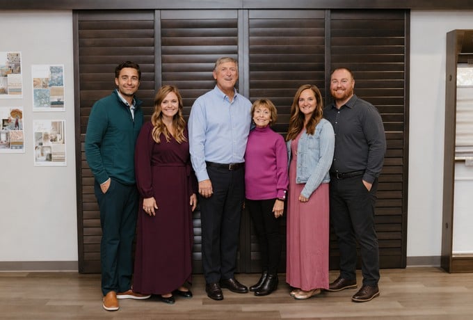 Three owner couples (six adults) of Budget Blinds of Iowa City in front of dark wood shutters