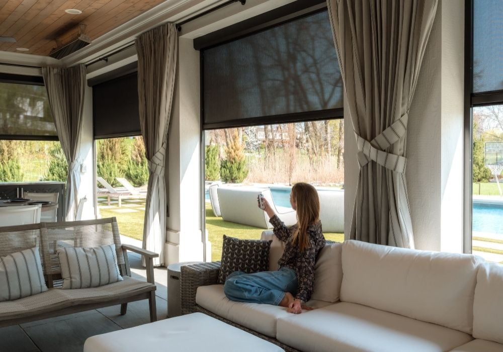 Exterior solar shades and outdoor drapes in a covered patio.