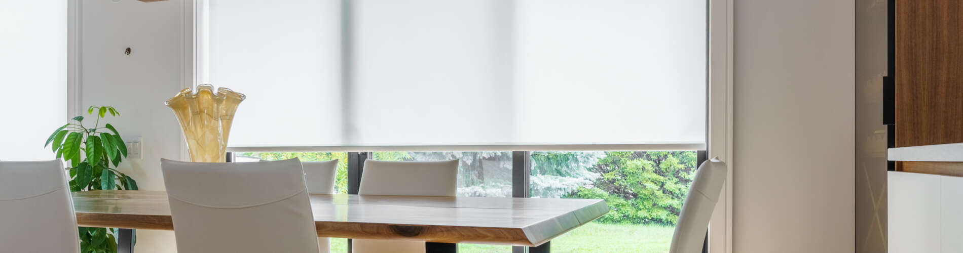 white roller shades over slider in dining room