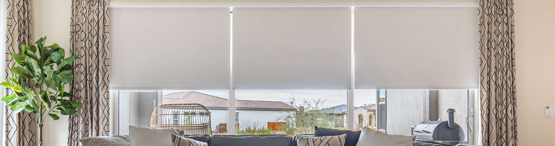 roller shades and drapery over sliding glass door in living room
