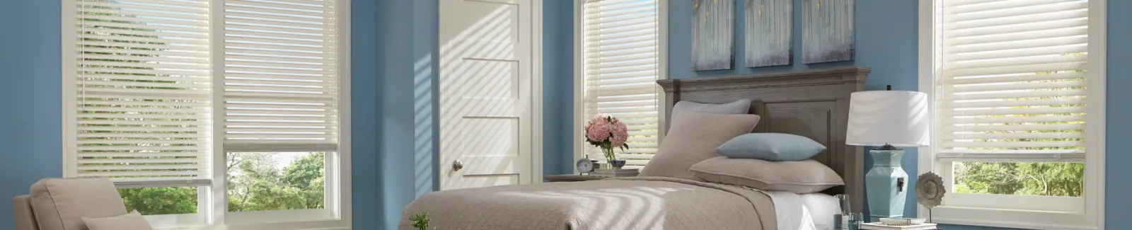 white blinds hanging in a light blue bedroom