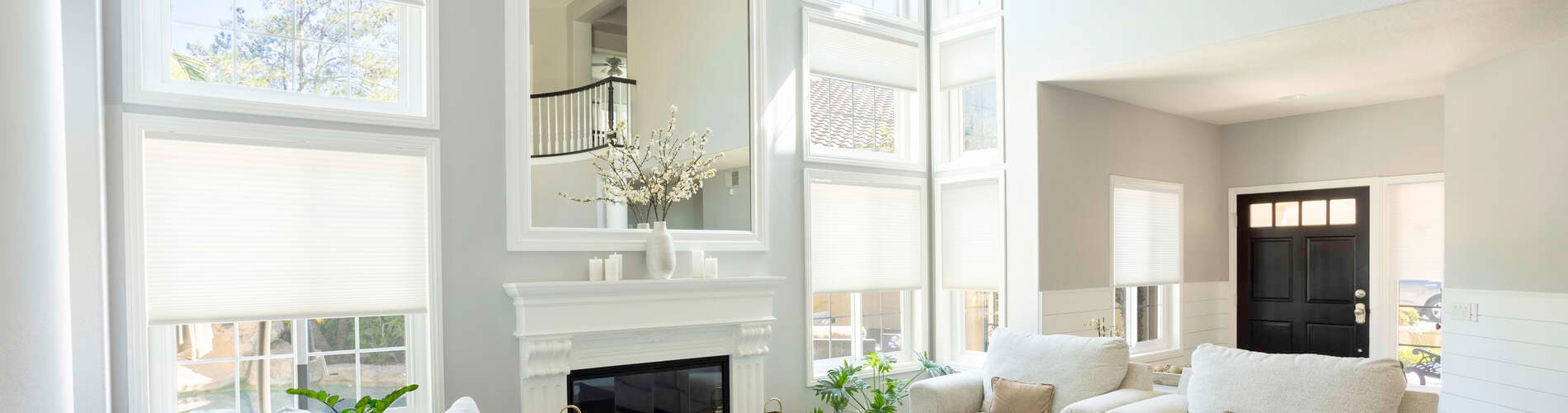 white cellular shades in living room with tall windows 
